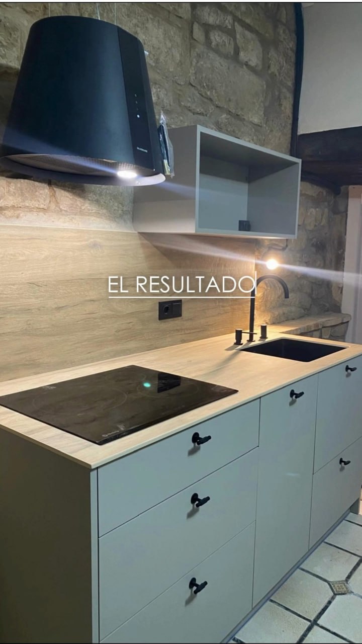 El espacio terminado — reforma final con pared de piedra original